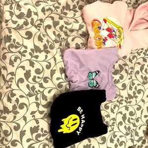 3 sweaters one in purple the second in pink and on in black